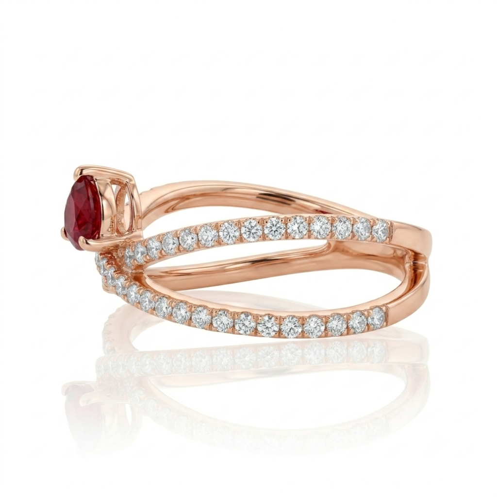 Sortija realizada en oro rosa de 18 K, con un brazo doble cruzado, pavonado con diamantes talla brillante y con un rubí en talla pera engastado en garras.