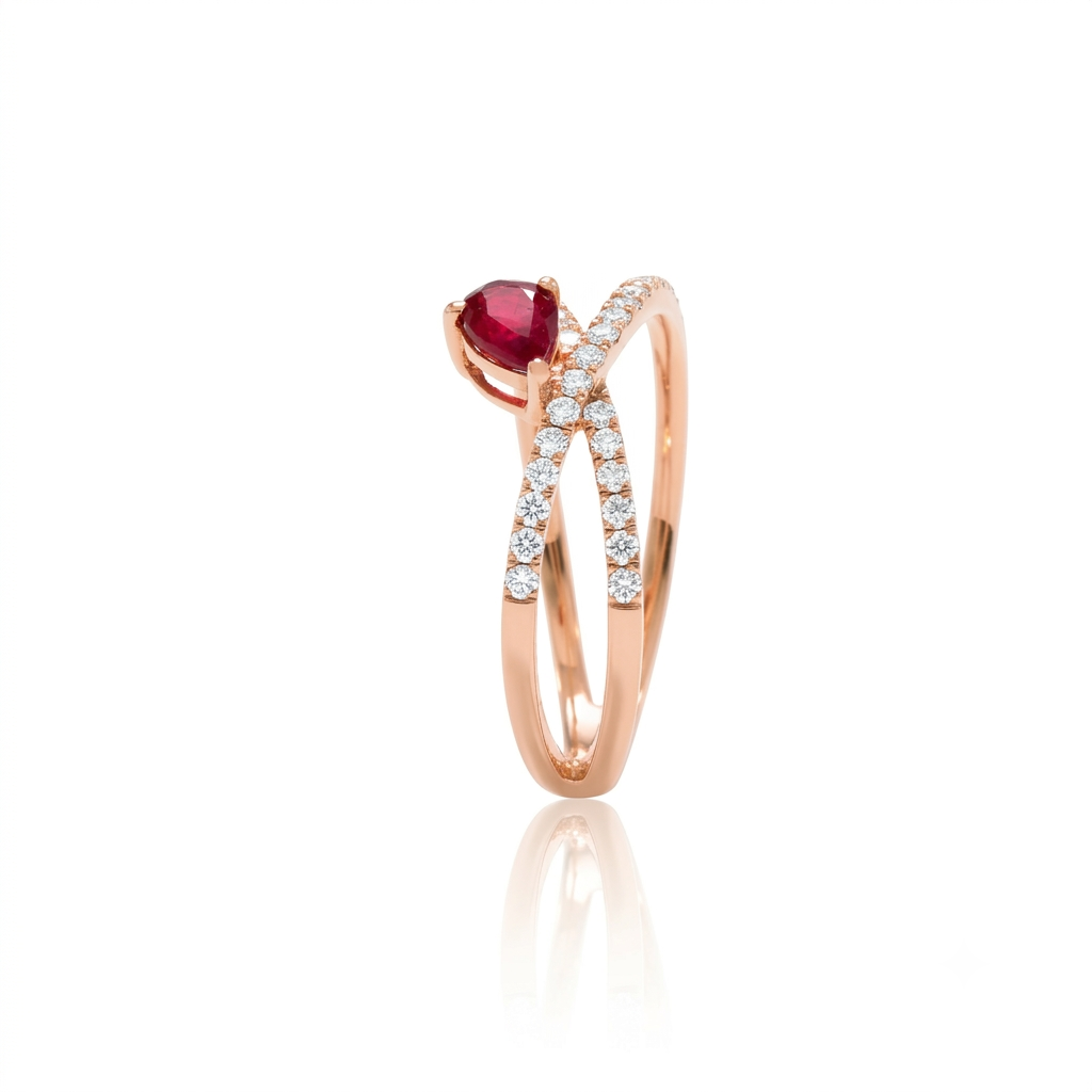 Sortija realizada en oro rosa de 18 K, con un brazo doble cruzado, pavonado con diamantes talla brillante y con un rubí en talla pera engastado en garras.