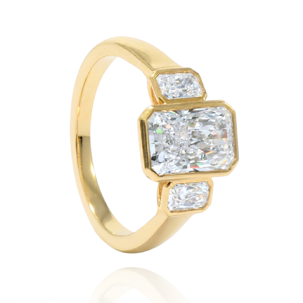 Anillo de oro amarillo de 18 quilates con diamante central de laboratorio talla esmeralda de 2,02 quilates y dos diamantes laterales talla esmeralda.
