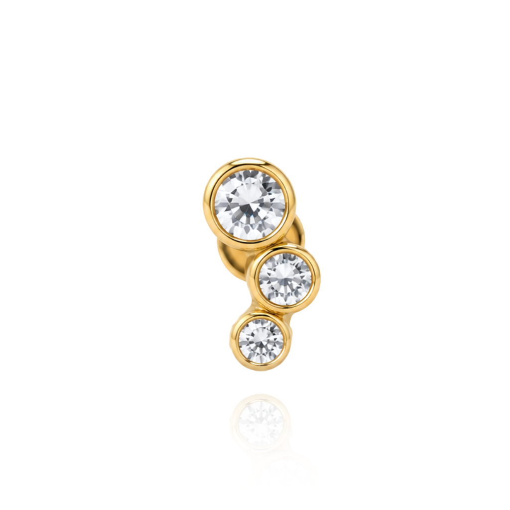 Piercing realizado en oro de 18 quilates con tres circonitas.