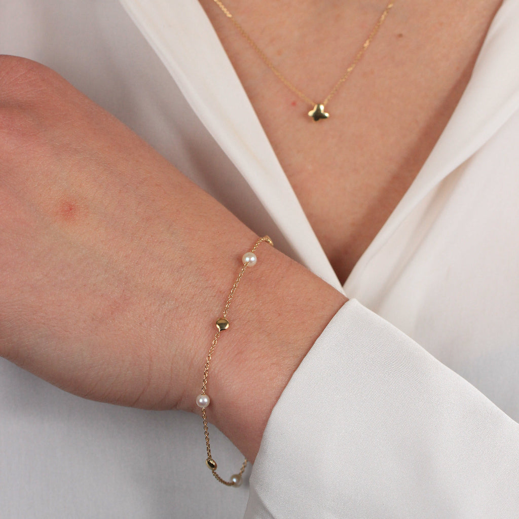 Pulsera realizada en oro amarillo de 18 quilates con motivos circulares lisos y perlas cultivadas