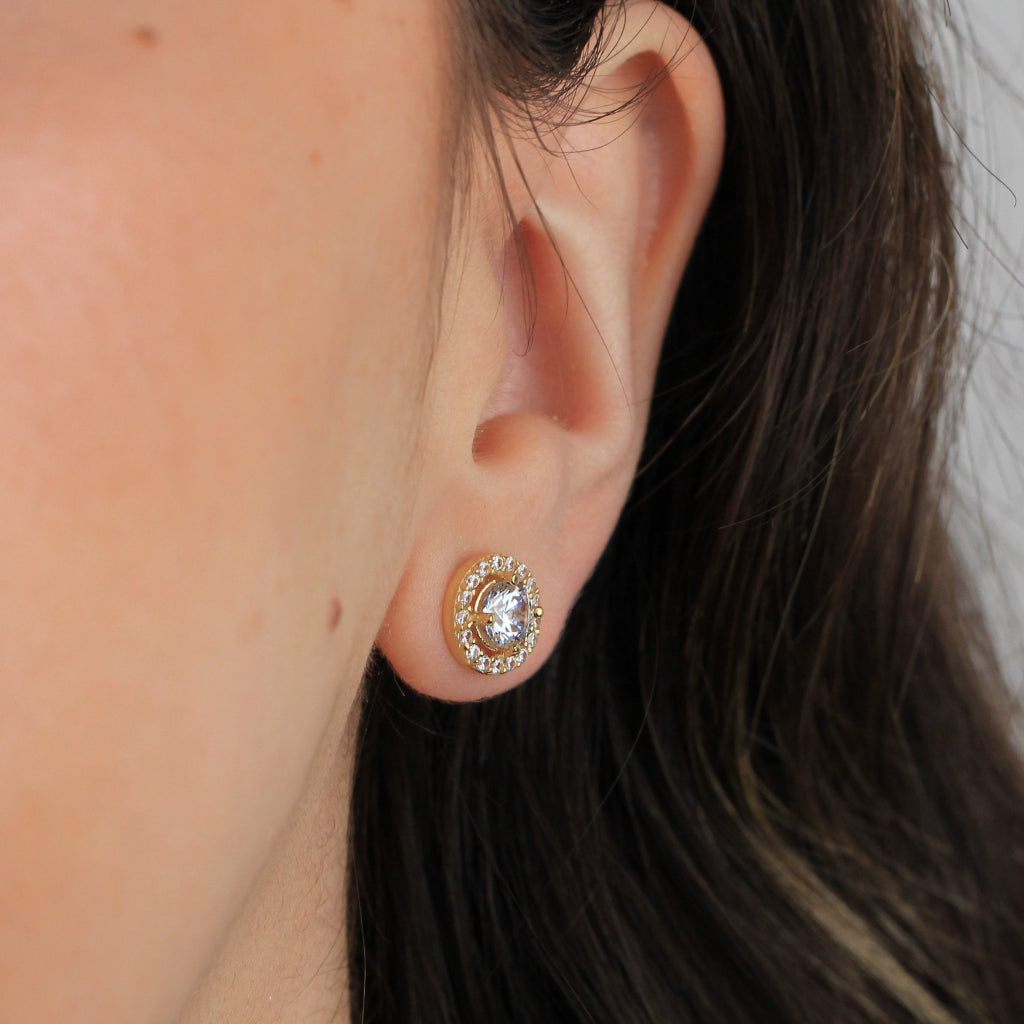 Pendientes realizados en oro amarillo de 18 quilates con una circonita central y una orla de circonitas.