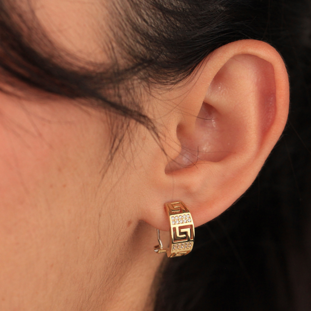 Pendientes realizados en oro amarillo de 18 quilates tipo aro con motivo greca y circonitas.
