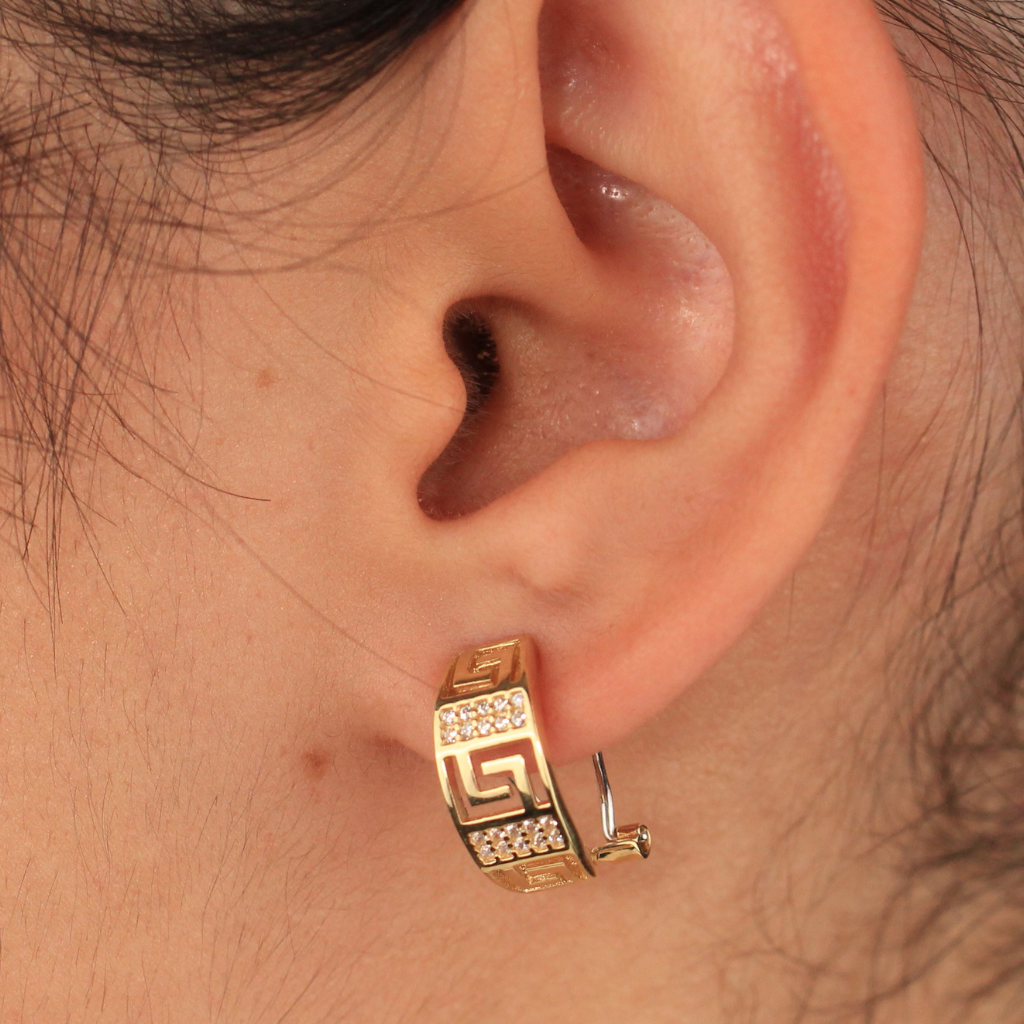 Pendientes realizados en oro amarillo de 18 quilates tipo aro con motivo greca y circonitas.