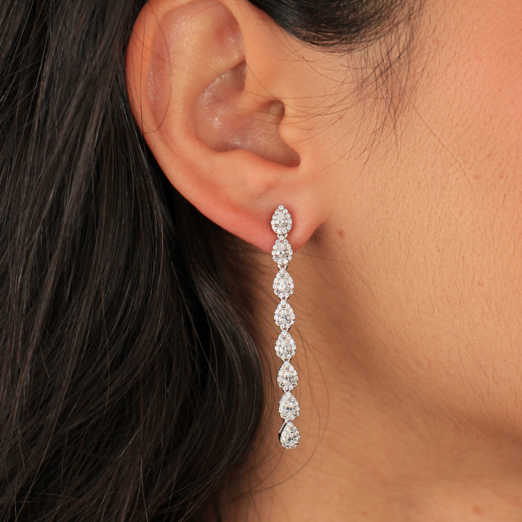 Pendientes largos realizados en plata de primera ley con una caída de ocho circonitas incoloras en forma de lágrima con orlas de circonitas. 
