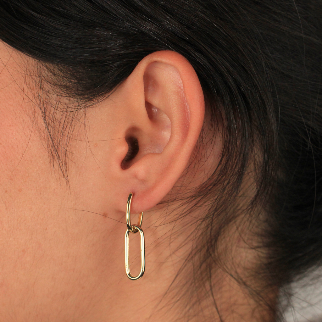 Pendientes realizados en oro amarillo de 18 quilates tipo aro con colgante de eslabón ovalado.