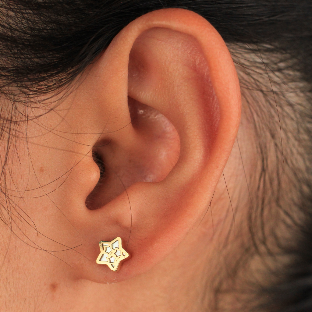 Pendientes realizados en oro amarillo de 18 quilates con motivo estrella calada y nácar.