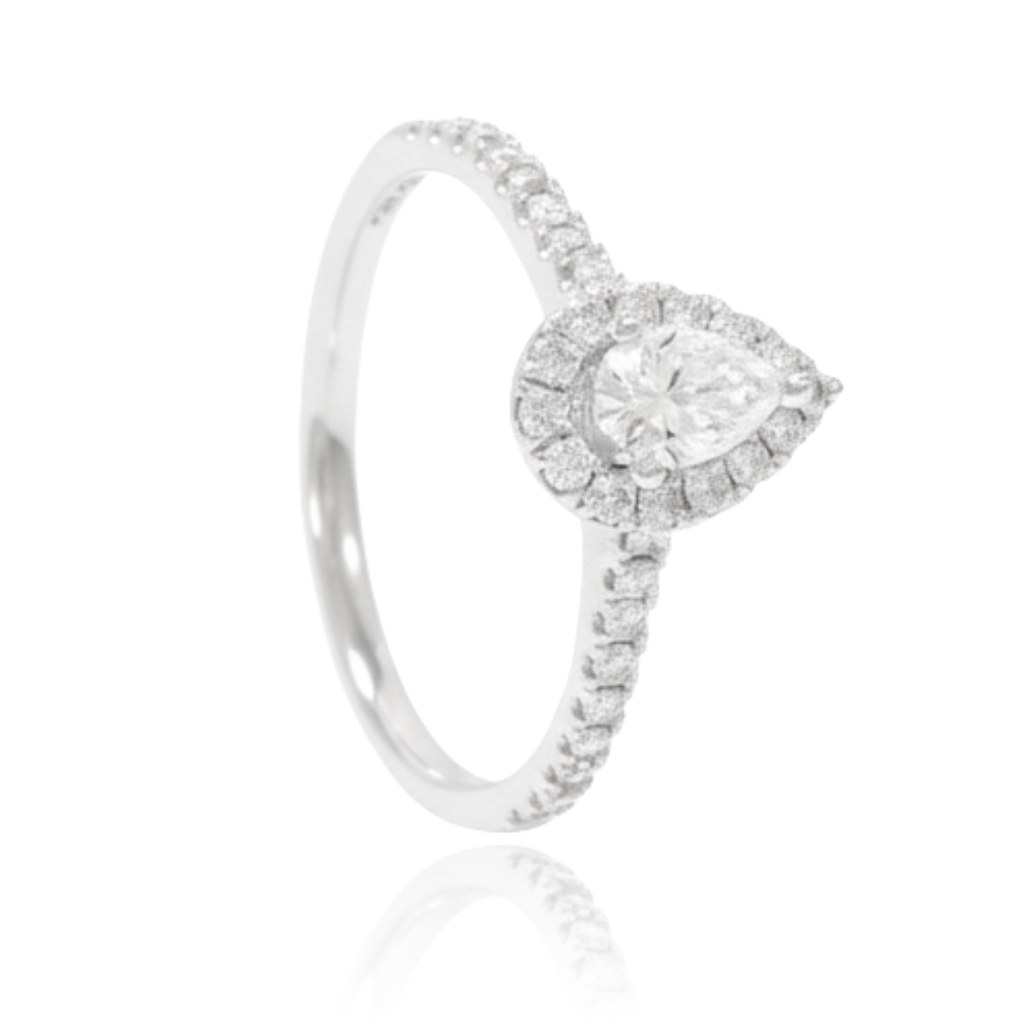 anillo de compromiso en oro blanco de 18 quilates con diamante talla pera con orla de diamantes y diamantes en los laterales