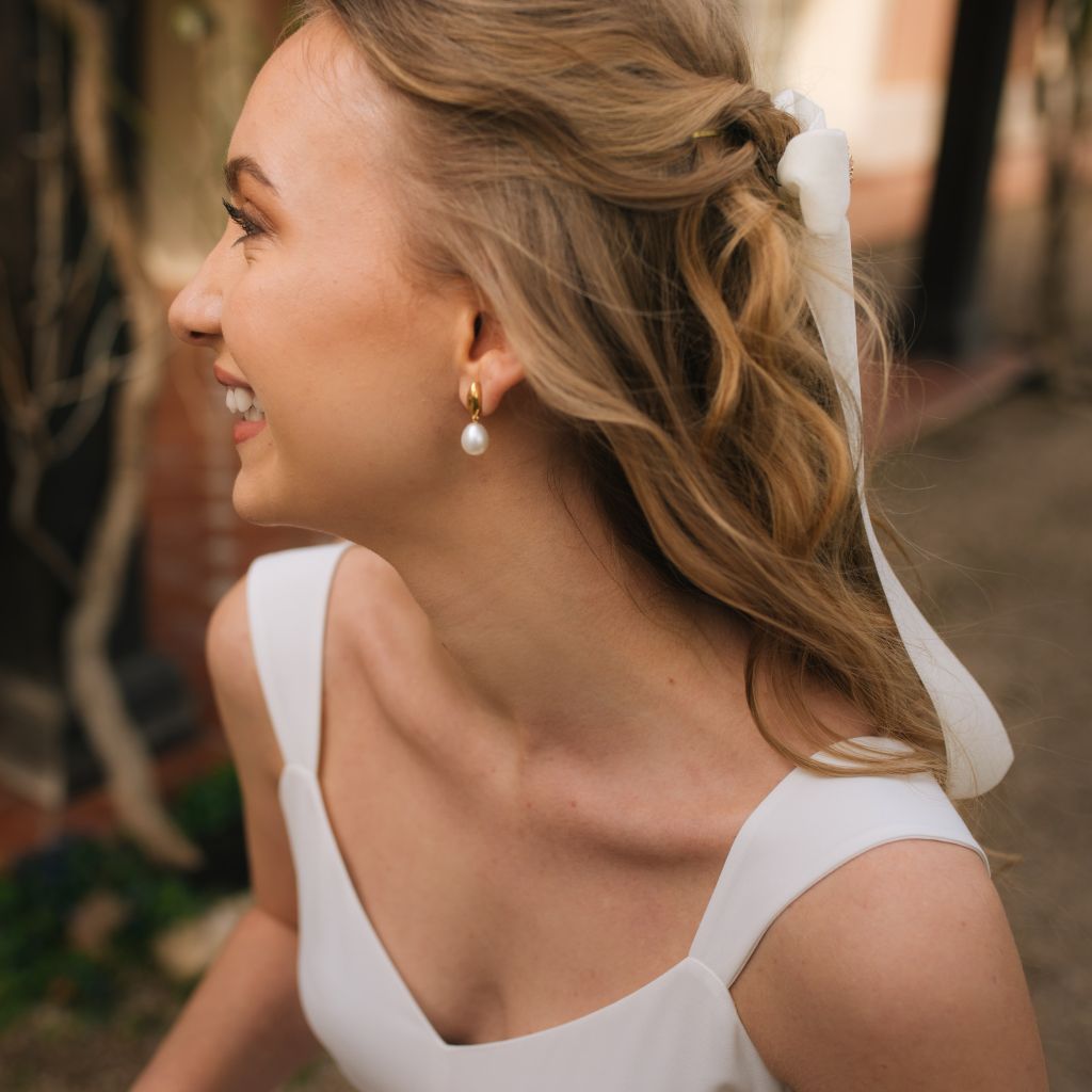 Novia con pendientes de oro y perlas