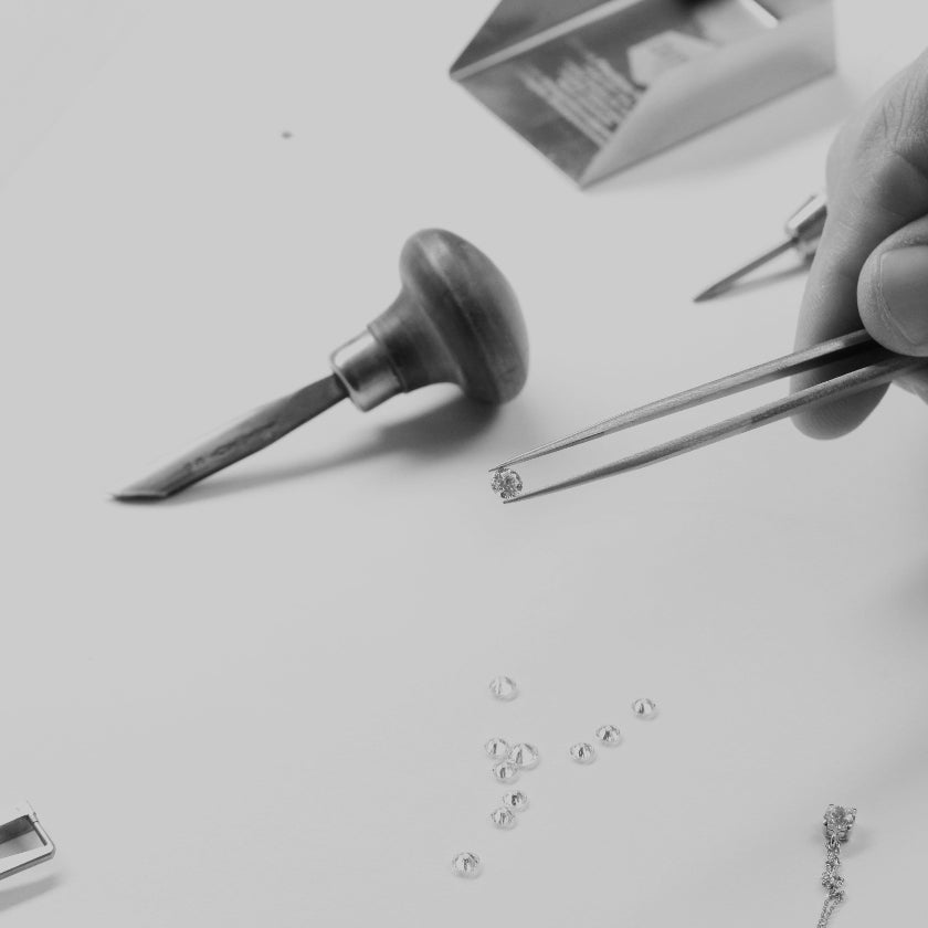 Diamante de joyería sujeto con pinzas de taller