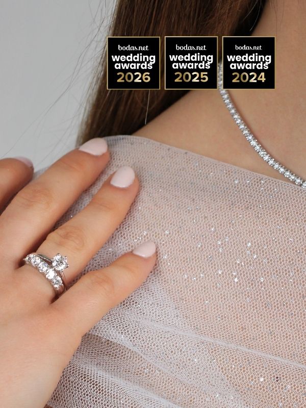 Anillo solitario y carril de compromiso en oro blanco y diamantes en mano de modelo