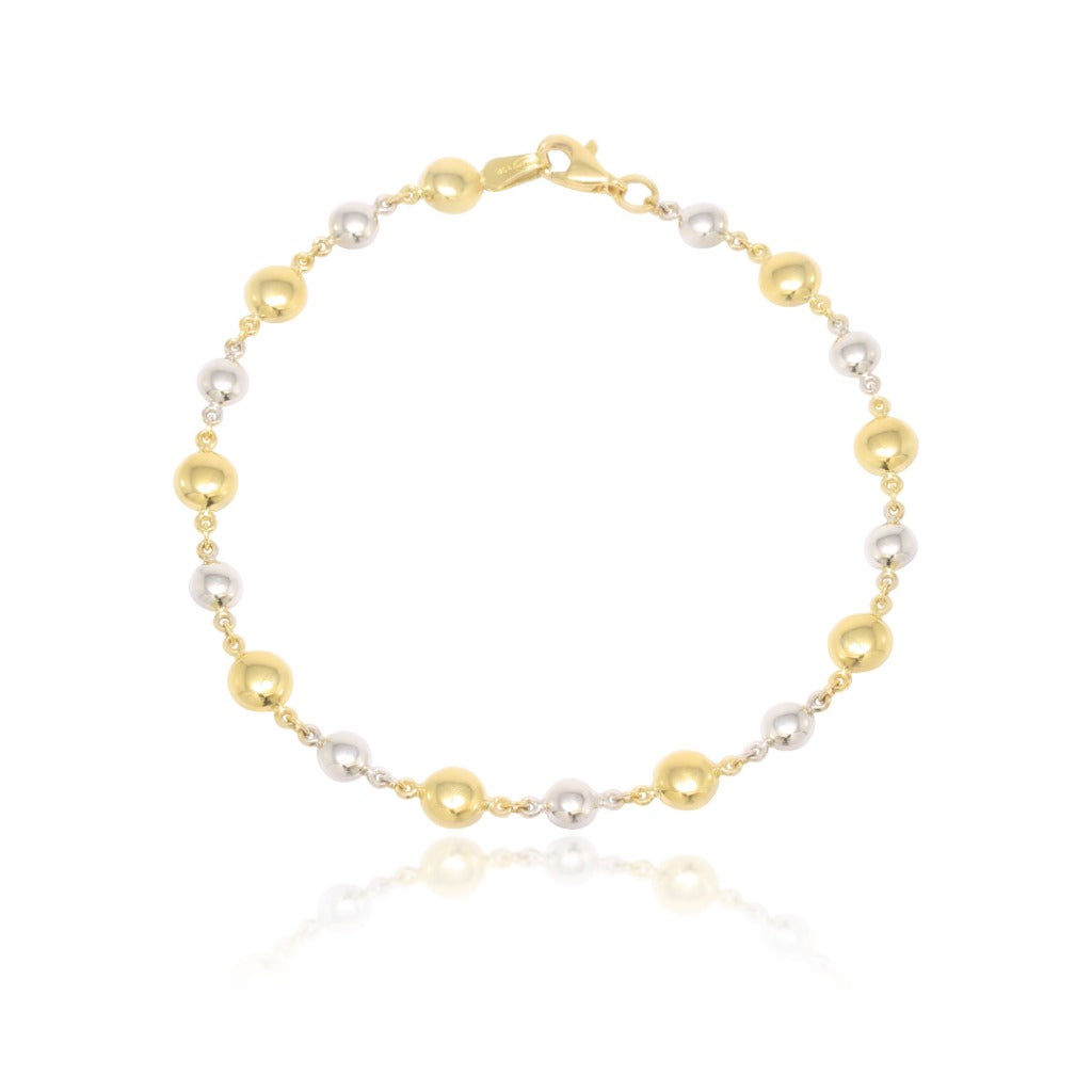 Pulsera bicolor realizada en oro amarillo y oro blanco de 18 quilates con motivos circulares.