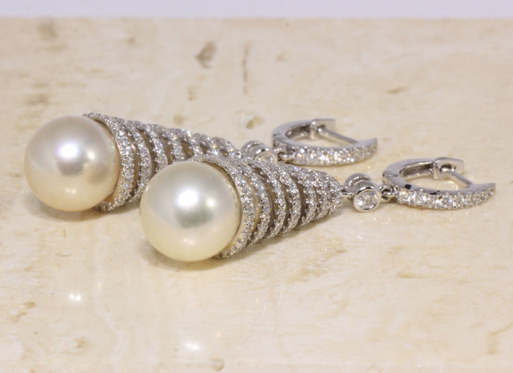 Pendientes de oro blanco de 18 quilates en forma de cono con un total de doscientos noventa y seis diamantes talla brillante con un peso de 1,75 cts. Terminados en dos perlas cultivadas.
