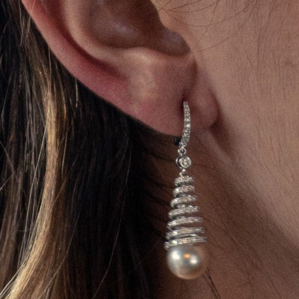 Pendientes de oro blanco de 18 quilates en forma de cono con un total de doscientos noventa y seis diamantes talla brillante con un peso de 1,75 cts. Terminados en dos perlas cultivadas.