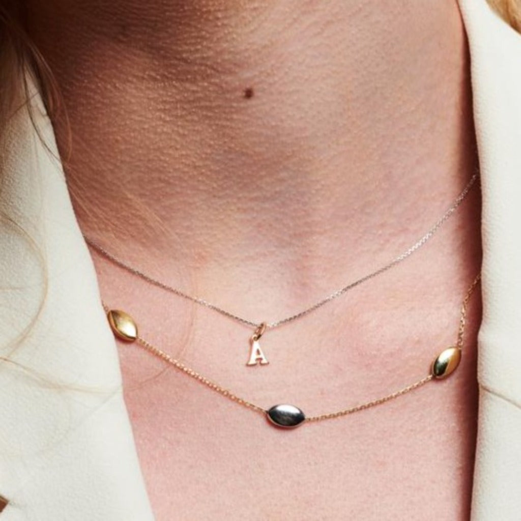 Cadena en oro blanco de 18 quilates con inicial en oro rosa de 18 quilates. Joyería Pamplona.